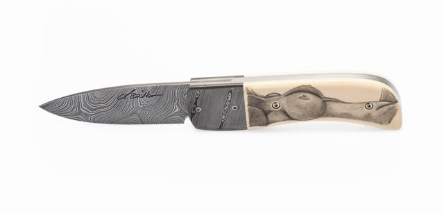 Linerlock Klappmesser 
Klinge: Torsionsdamast
Griff: Mammutelfenbein mit Torsionsdamastbacken
Gravur: Scrimshaw Aktmotiv 